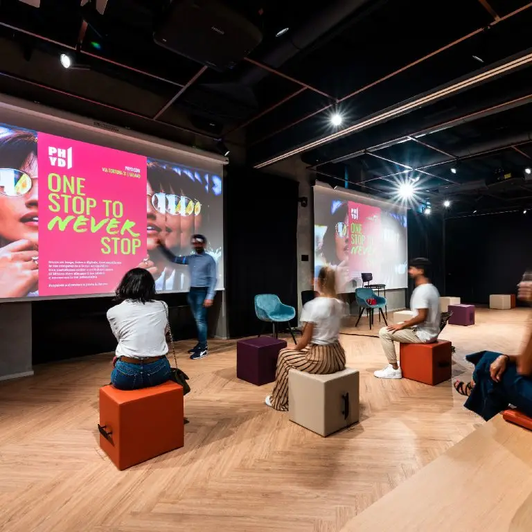 Quattro persone sedute davanti una proiezione nello spazio Phyd durante una formazione