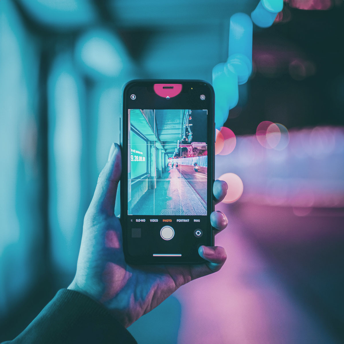 Una mano che tiene un cellulare con la fotocamera attiva