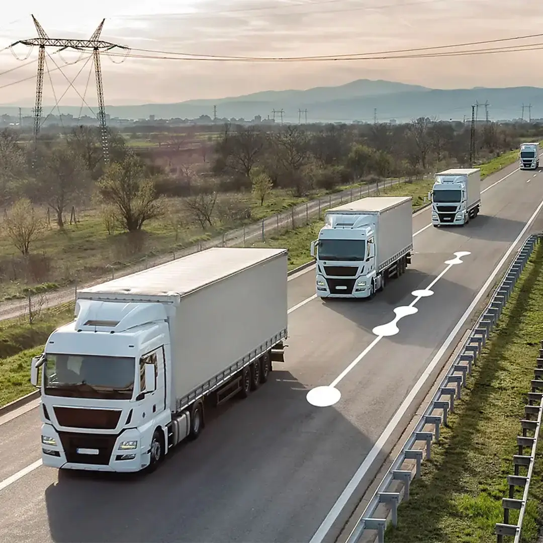 Tre camion procedono in fila, segnali tecnici sullautostrada.