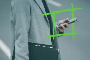 Persona in cappotto grigio che tiene in mano uno smartphone e una cartella nera, con sovrapposizione grafica verde, che simboleggia l'innovazione e il successo dell'e-mail marketing.