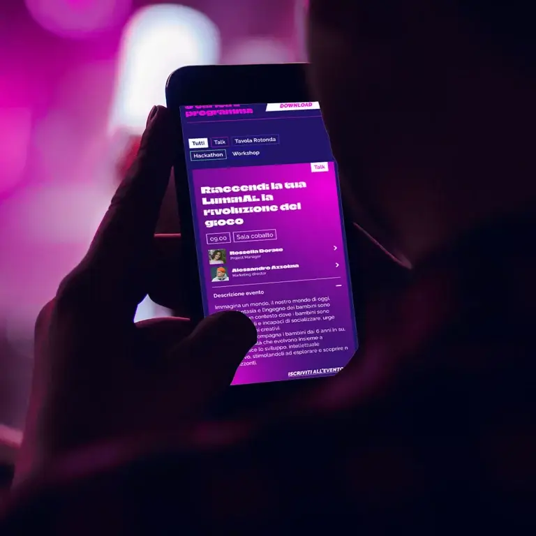 Lo smartphone mostra lapp viola in italiano, sfondo rosa.