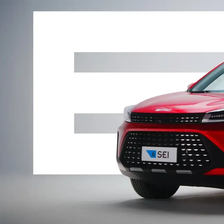 Primo piano della parte anteriore di unauto rossa, griglia, sfondo grigio, E, targa 6 SEI.