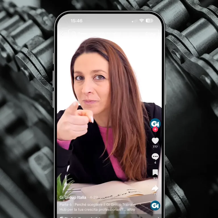 Una donna con lunghi capelli castani punta la telecamera su TikTok con il telefono.