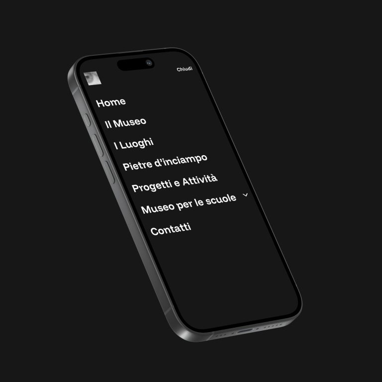 Il telefono mostra il menu del museo italiano: Home, Progetti, Scuole, Memoria.