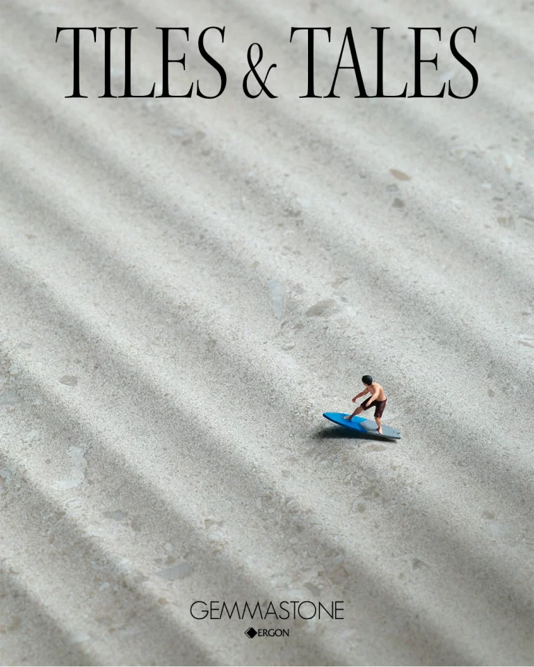 Figurina di surfista su tavola blu in cima a piastrelle ondulate, TILES & TALES e GEMMASTONE in alto.