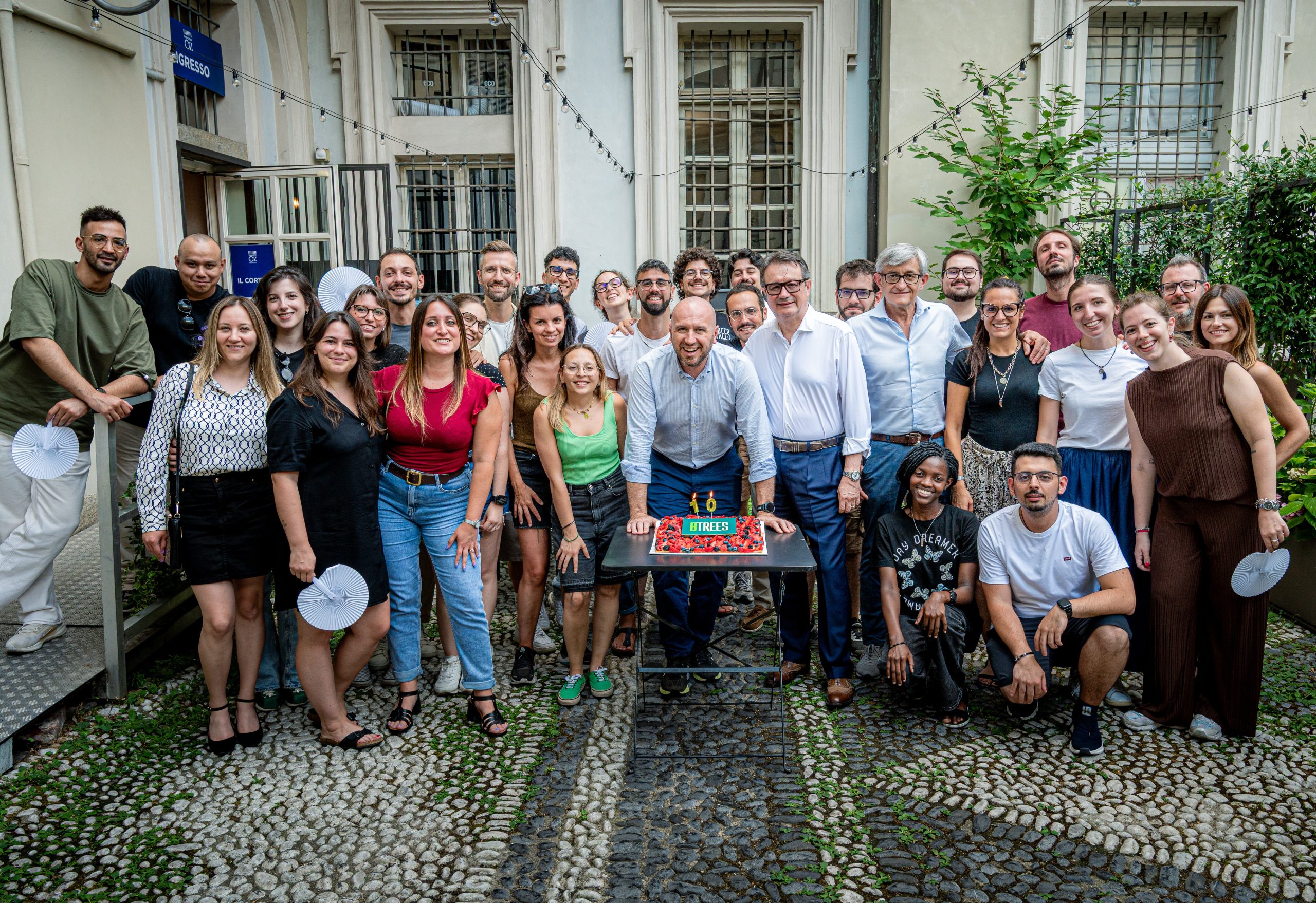 Il team BTREES festeggia con una torta all'aperto, sorridendo per il 2025.